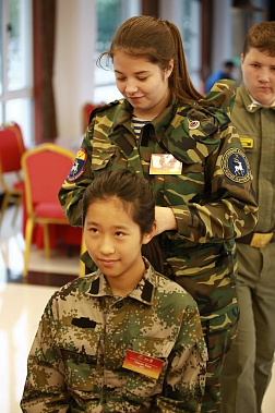 Косова Мария заплетает косу китайской девочке.