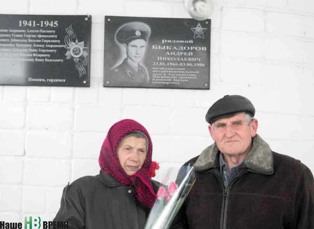 Родители Андрея у мемориальной доски сына.
