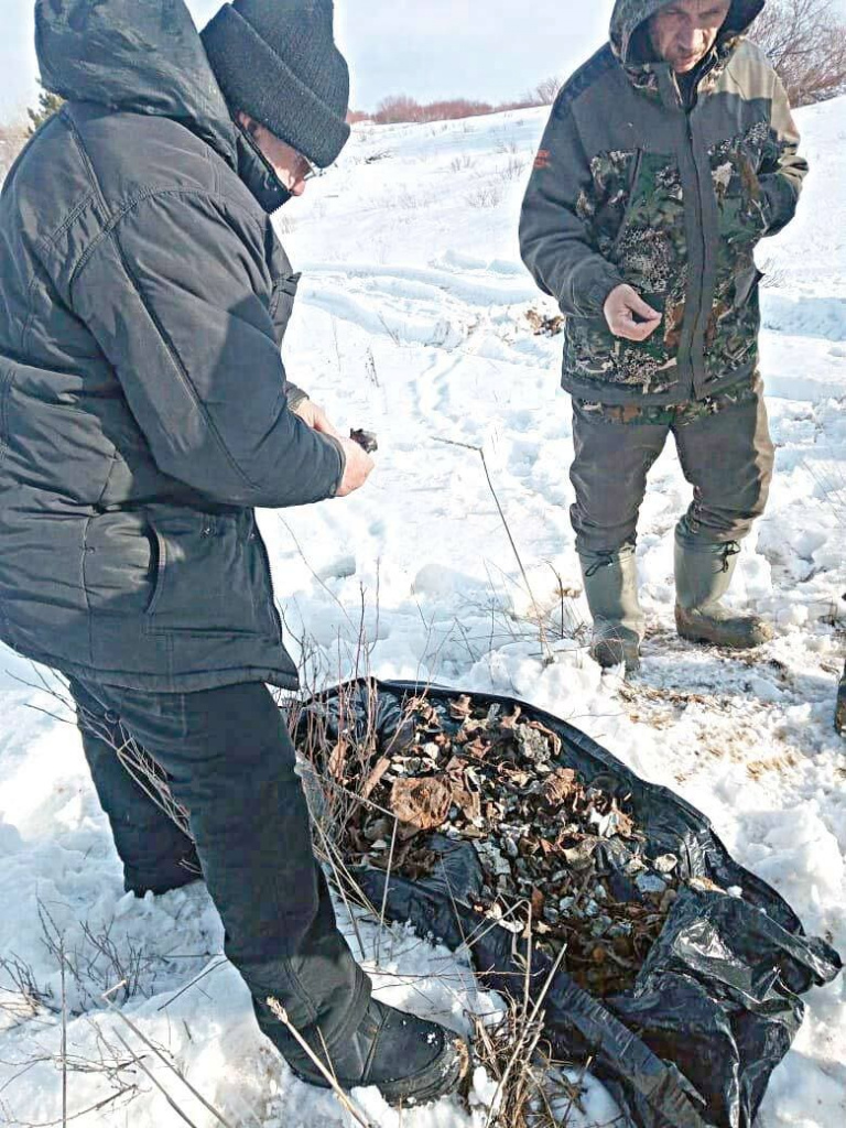 Поисковики Виктор Демченко и Владислав Камбулов собирают мелкие фрагменты фюзеляжа самолета, крупные находятся на глубине.