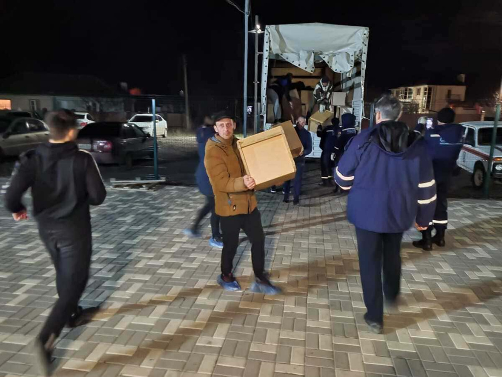 Жители хутора Ленина разгружают машину с продуктами от Ростовской епархии.