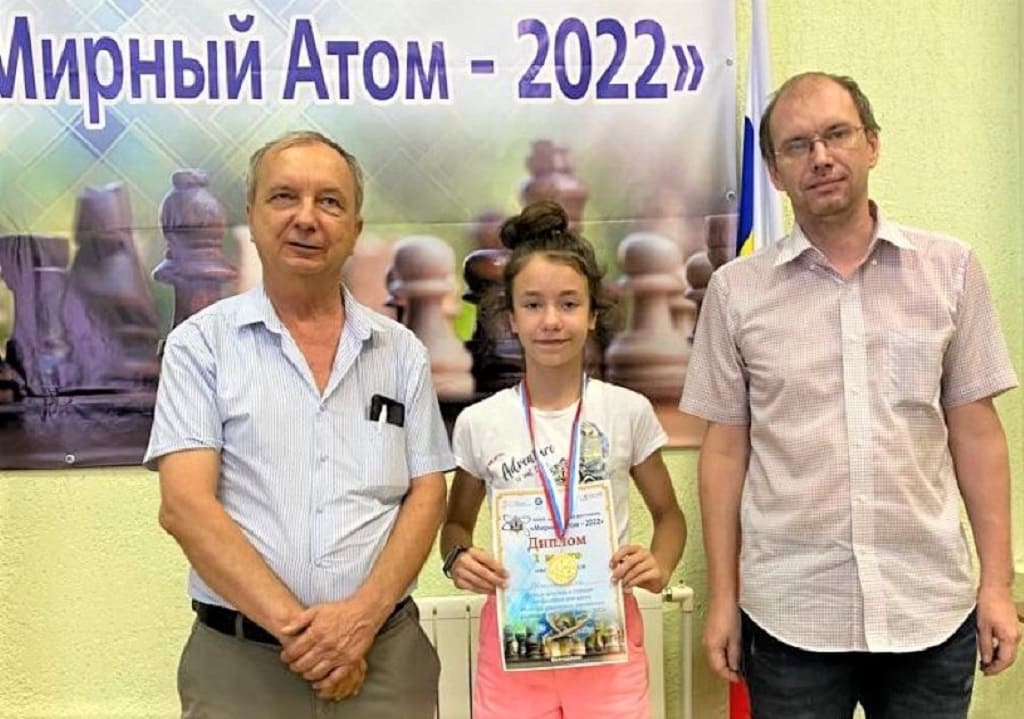 Организаторы фестиваля Владимир БЕЛЯЕВ и Алексей ТРЕТЬЯКОВ с азовчанкой Юлией ЕВТЕЕНКО («Читает «Наше время» и играет за «Наше время-100»), отличившейся в блице