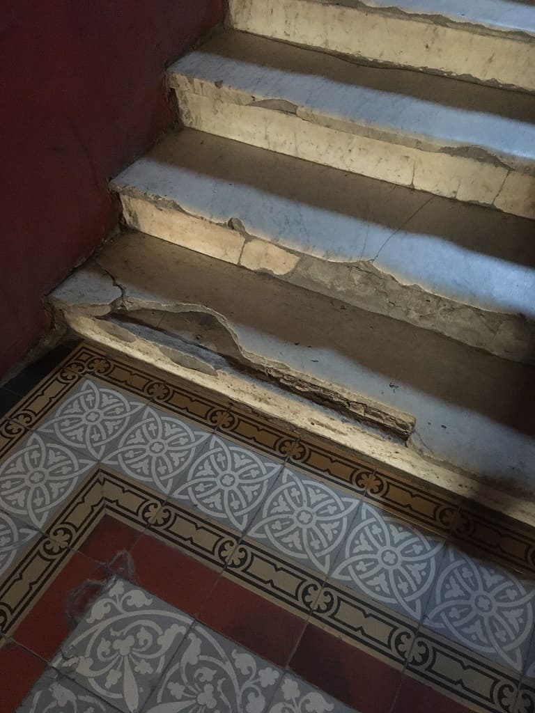 Следы былой роскоши: мраморные ступени и метлахская плитка на полу.