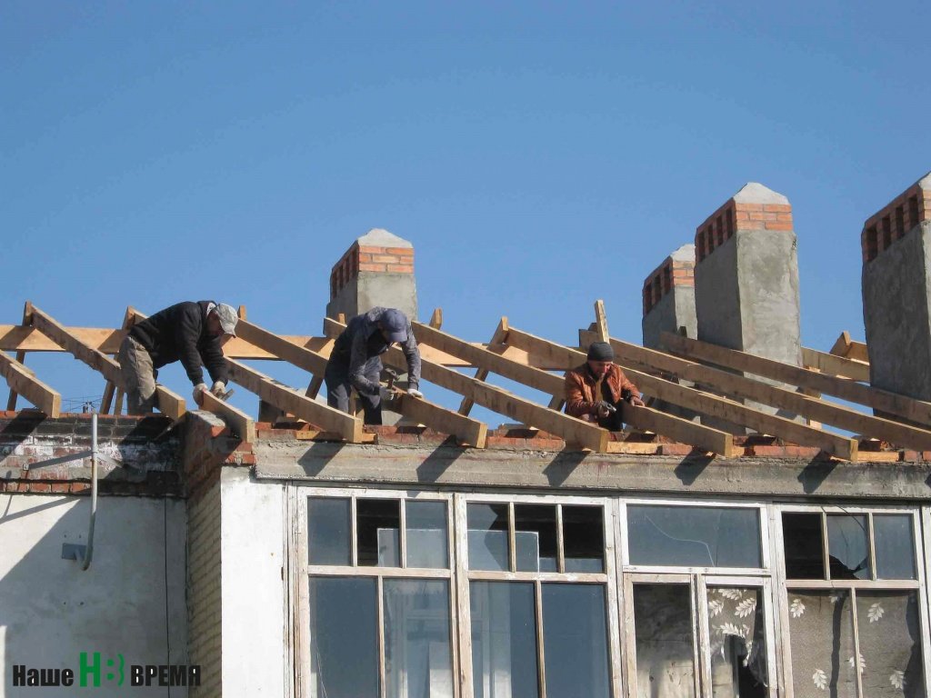 На крыше дома полным ходом идут восстановительные работы.