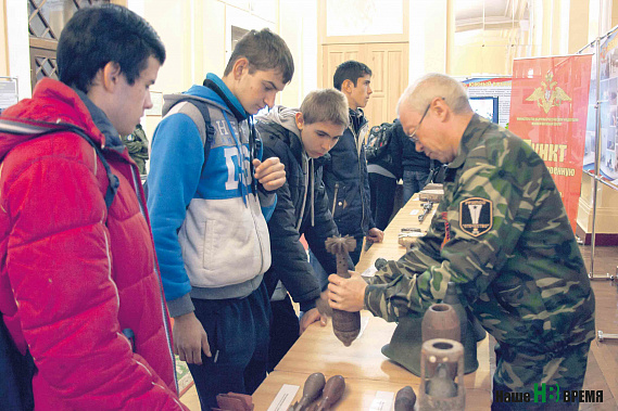 Сергей Рагуленко показывает мальчишкам боеприпасы Второй мировой войны.