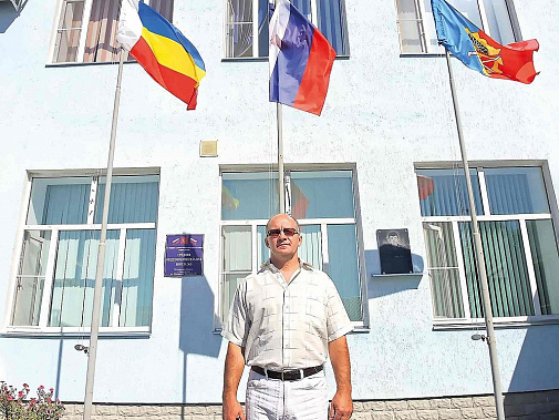 Виктор Вдовенко, замначальника районного управления образования, с гордостью позирует у здания отремонтированной школы №5.