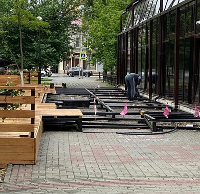 Рабочие освобождают тротуар от элементов летней веранды