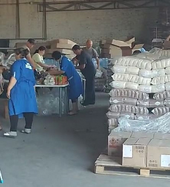 В большом ангаре собирали во второй рейс четыре КамАЗа с гуманитарной помощью.