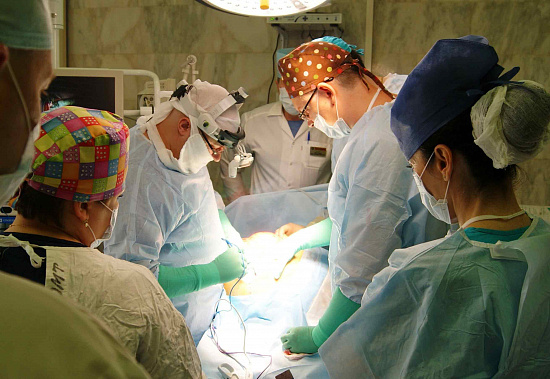 Оперирующий хирург Олег Кит с ассистентами РНИОИ удаляет опухоль весом 37 кг.
