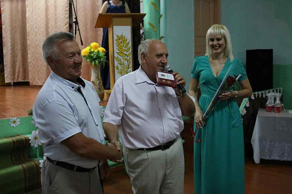 Заместитель главы администрации района Александр Третьяков вручает знак «80 лет Ростовской области» Александру Слинько.