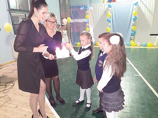 Первоклашки зажигают свечу, символизирующую любовь.