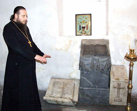 Отец Алексей показывает раритеты, обнаруженные в подземелье старой таганрогской церкви.