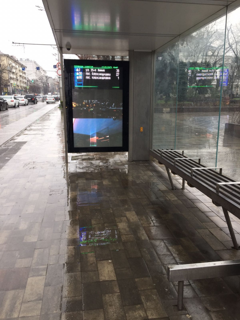 Новая умная остановка, которая в дождь заливается водой, так что если бы здесь стояли люди и ждали транспорт, они были бы все мокрыми.